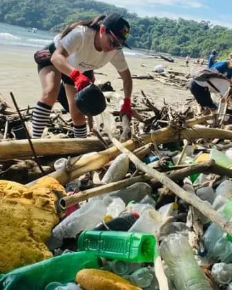 A team collecting plastic waste on a riverbank